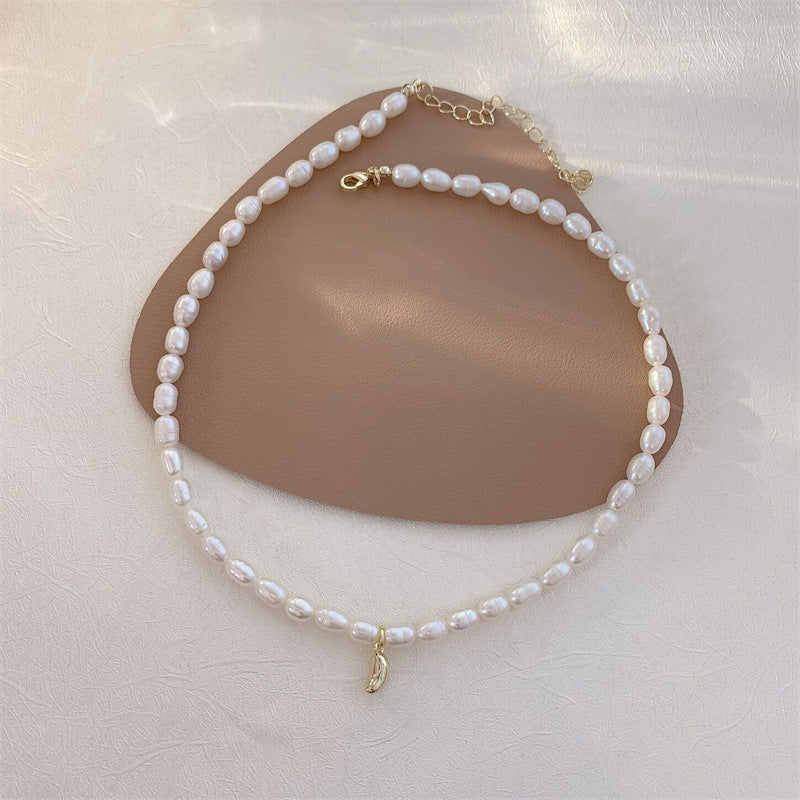 Colier scurt din perle cu pandantiv auriu